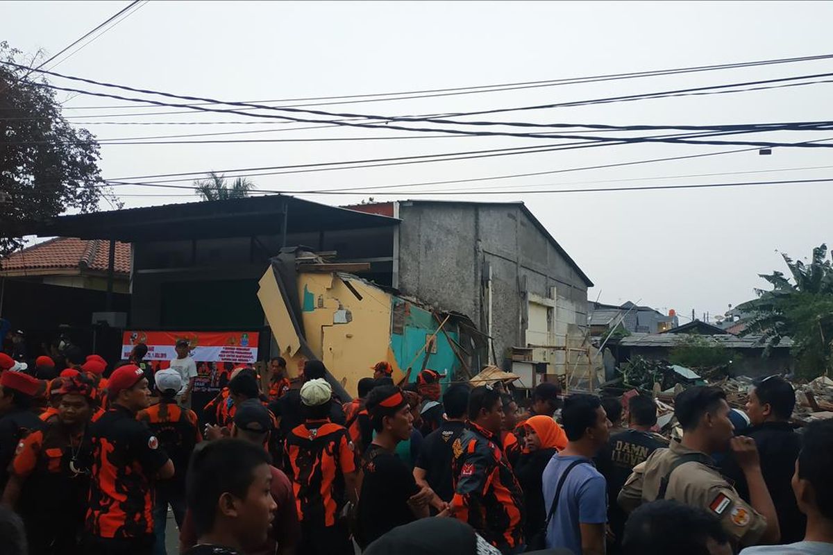 Penggusuran perumahan warga di Jalan Bougenville Raya RT 001 RW 011 Jakasampurna, Bekasi Barat ditunda hingga waktu yang tidak ditentukan, Kamis (25/7/2019). Rumah terakhir yang dibongkar tepat di samping rumah berspanduk salah satu ormas yang dijaga seharian oleh puluhan anggotanya.