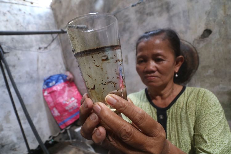 Warga memperlihatkan air bercampur minyak yang diambil dari sumur di Kelurahan Tempurejo, Kota Kediri, Jawa Timur, Senin (11/9/2023). Sebanyak 14 sumur warga yang terletak di dekat Stasiun Pengisian Bahan Bakar Minyak (SPBU) di wilayah tersebut tercemar minyak. ANTARA FOTO/Prasetia Fauzani/aww.