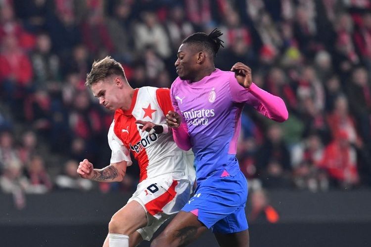 Rafael Leao (kanan) berduel dengan Conrad Wallem dalam laga leg kedua 16 besar Liga Europa 2023-2024 antara Slavia Praha vs Milan di Eden Arena, 14 Maret 2024. (Photo by Michal Cizek / AFP)