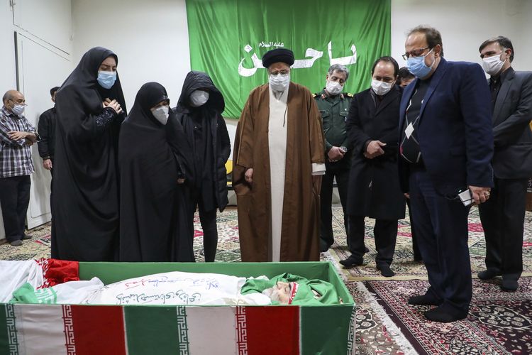 Ketua Kehakiman Iran Ayatollah Ebrahim Raisi memberikan penghormatan terakhir di depan jenazah ilmuwan nuklir Mohsen Fakhrizadeh di Teheran, pada 28 November 2020. Fakhrizadeh dibunuh sehari sebelumnya dengan Iran menuding Israel sebagai pelakunya.