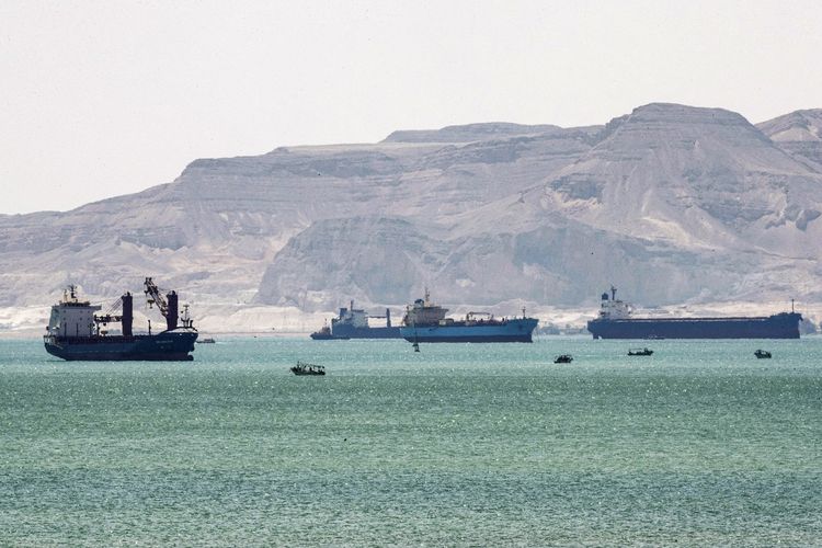 Foto pada Minggu (28/3/2021) menunjukkan kapal tanker dan kapal barang mengantre masuk di dekat gerbang Terusan Suez. Terusan Suez macet akibat kapal Ever Given tersangkut di kedua sisi kanal.