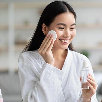 Ilustrasi membersihkan wajah dengan cleanser wajah.