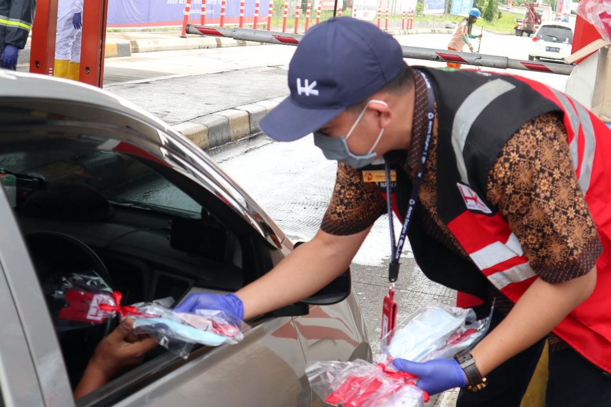 Pemberian masker gratis yang dilakukan oleh petugas dengan pengguna jalan tol.