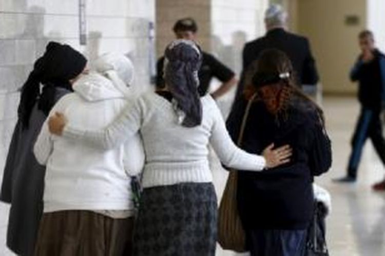 Perempuan Israel, teman dan keluarga dua militan Yahudi yang menurut Radio Israel, didakwa lakukan serangan mematikan pada 31 Juli, berjalan di luar ruang pengadilan di Lod, Israel tengah, 3 Januari 2016.
