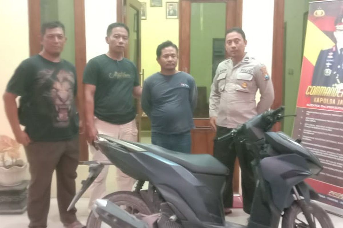 Pelaku (tengah) berikut barang bukti sepeda motor hasil curian diamankan di kantor Polsek Karanggeneng, Lamongan, Jawa Timur, usai kepergok coba menawarkan sepeda motor tersebut melalui media sosial (medsos), Minggu (15/9/2024).