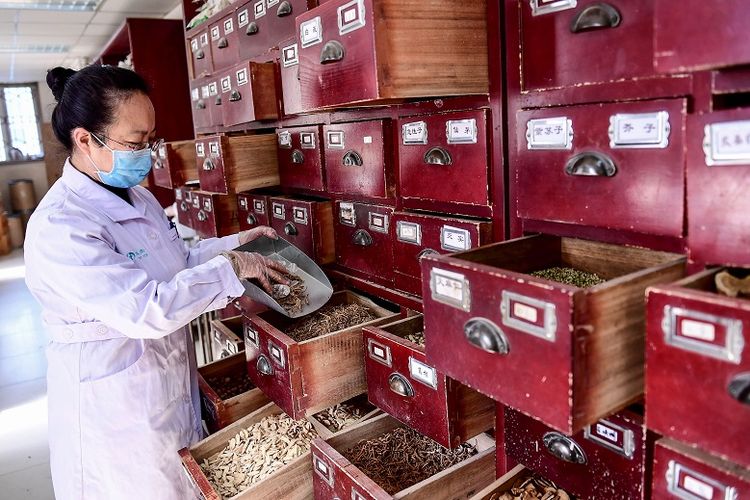 Foto ini diambil pada 20 Februari 2020 menunjukkan seorang pekerja medis mengambil resep obat tradisional China di sebuah rumah sakit di Shenyang di provinsi Liaoning, China timur laut.