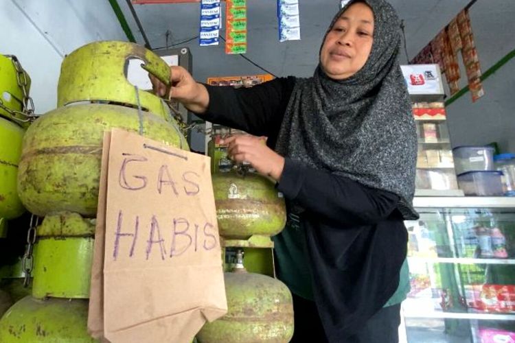 Siti Saudah memasang potongan karton bertuliskan gas habis di toko miliknya di Jalan Bengawan Solo, Kota Blitar, Selasa (25/7/2023).
