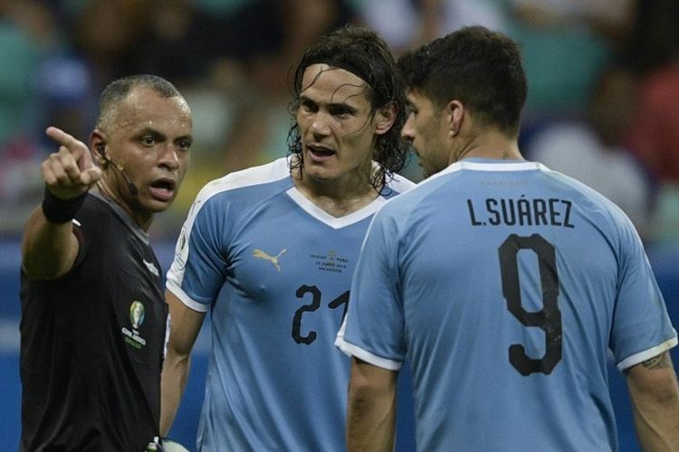 Brazilian referee Wilton Pereira Sampaio talks to Uruguay's Edinson Cavani (C) and Luis Suarez as he conducts the Copa America football tournament quarter-final match between Uruguay and Peru at the Fonte Nova Arena in Salvador, Brazil, on June 29, 2019. (Photo by Juan MABROMATA / AFP)