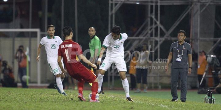 Pemain Indonesia, Septian David Maulana, dibayangi pemain Vietnam.