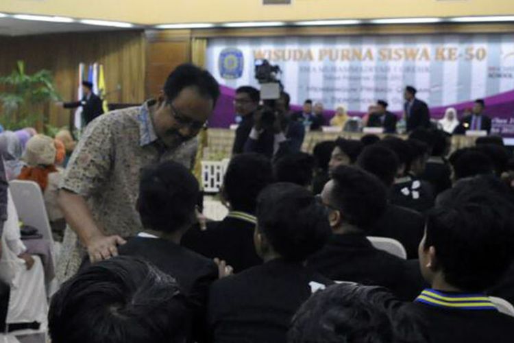 Wakil Gubernur Jawa Timur Syaifullah Yusuf (tengah), selepas menghadiri acara pelepasan siswa SMA Muhammadiyah 1 Gresik.