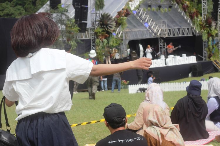 Seorang penonton antusias menari mengiringi band Mocca yang tampil memukau dalam konser musik bertajuk Sunset di Kebun Raya Cibodas, Cianjur, Jawa Barat, Minggu (6/10/2024)