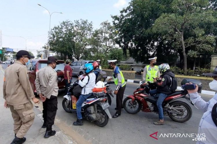 Aparat Kepolisian Polda Metro Jaya bersama Polres Metro Bekasi memberhentikan 200 pemudik di Jalur Pantura Kedungwaringin, Kabupaten Bekasi, Jawa Barat, Kamis (29/4). 