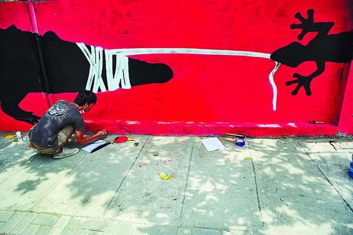 Komunitas 12 pm membuat mural yang bertemakan cicak menangkap buaya di Jalan Hayam Wuruk, Kota Semarang, Jawa Tengah, Minggu (25/10). Komite Penyelidikan dan Pemberantasan Korupsi, Kolusi, dan Nepotisme (KP2KKN) Jawa Tengah menggunakan mural tersebut sebagai media kampanye antikorupsi kepada masyarakat. 