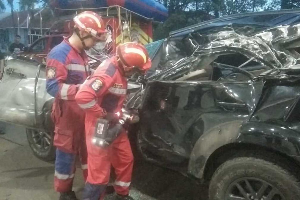 Dua petugas Damkar Kota Bogor saat melakukan penyelamatan langsung menangani korban dengan cara membuka dan memotong bagian pintu mobil dengan menggunakan alat combaintul rescue usai kecelakaan Fortuner di di Km 36.460 Jalur A (Jakarta arah Bogor) Sentul, Desa Cipambuan, Kecamatan Babakan Madang, Kabupaten Bogor, Jawa Barat, Minggu (14/1/2024).