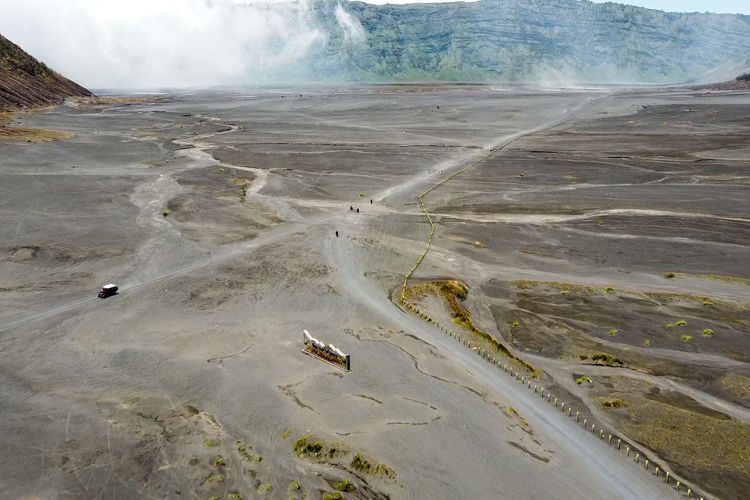 Kendaraan melintas di lautan pasir Bromo.