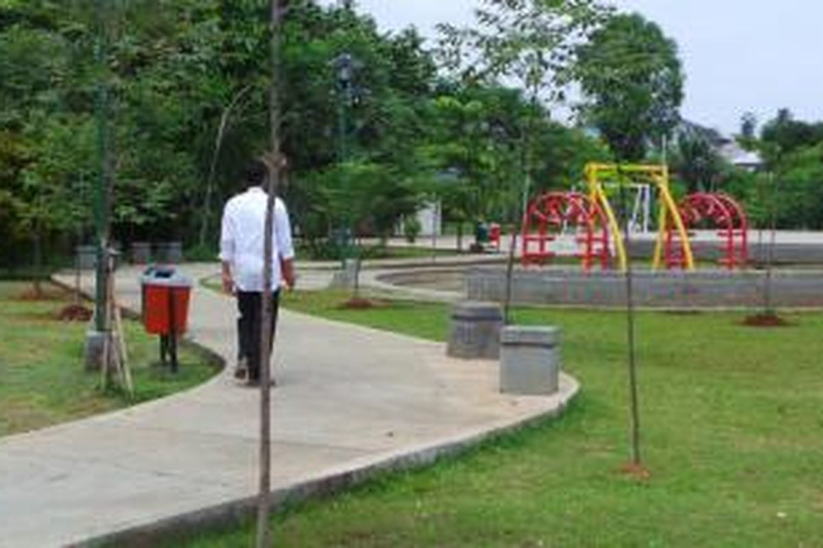 Gubernur DKI Jakarta Joko Widodo berjalan di Taman Mahoni, Ciracas, Jakarta Timur, Rabu (4/12/2013) siang. Dia menginginkan agar ada taman di tengah permukiman penduduk seperti taman tersebut.