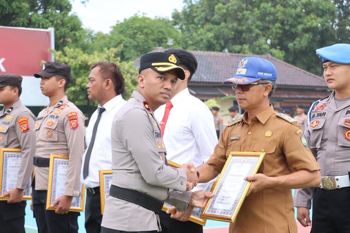 Wakapolres Indramayu Kompol Tahir Muhiddin saat memberikan penghargaan kepada Kepala Desa Babadan, Sugeng Sari Kusmanto karena sudah membantu mengungkap kasus pembunuhan satu keluarga di Mapolres Indramayu, Jawa Barat, Senin (8/9/2025)