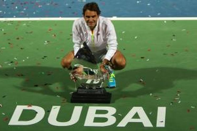 Petenis Swiss, Roger Federer, berpose dengan trofi Dubai Duty Free Tennis Championships setelah mengalahkan petenis Serbia, Novak Djokovic, pada laga final, Sabtu (28/2/2015).