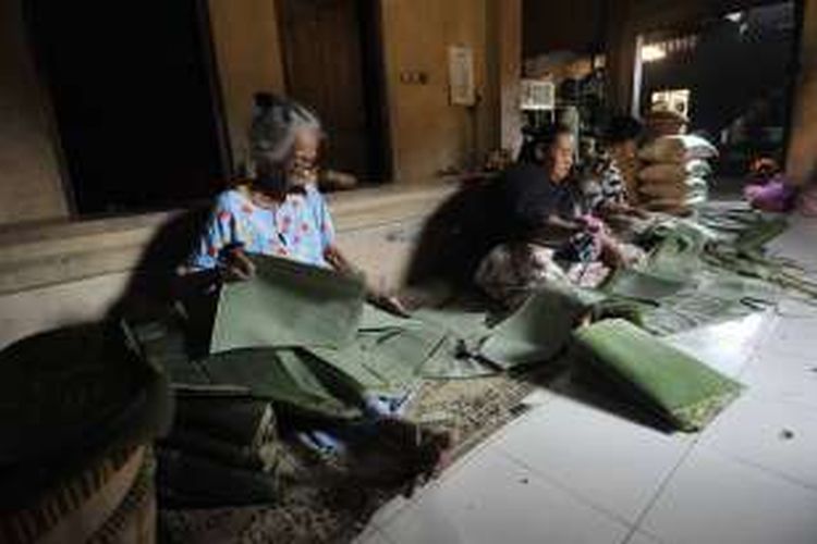 Mbah Djum (kiri) mengunyah sirih sembari melipat daun untuk pembungkus gudeg di rumah makan gudeg Yu Djum miliknya di Dusun Karangasem, Caturtunggal, Depok, Sleman, DI Yogyakarta, Jumat (24/6/2011).