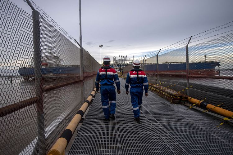 Pekerja PT Pertamina Hulu Rokan (PHR) berjalan menuju dermaga untuk mengecek proses pengapalan lifting minyak mentah produksi PHR di Dumai Terminal Oil Wharf, Dumai, Riau.