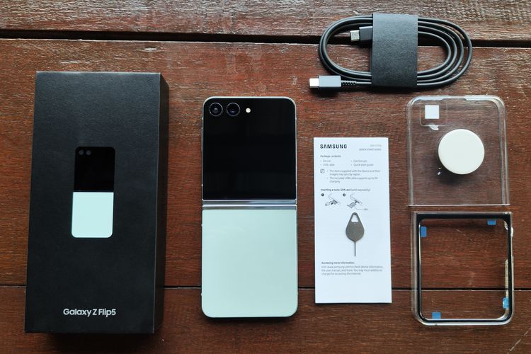 Kotak kemasan Samsung Galaxy Z Flip 5 berisikan satu unit Galaxy Z Flip 5, buku panduan, kabel charger tipe USB-C ke USB-C, SIM ejector, dan kasing transparan tambahan