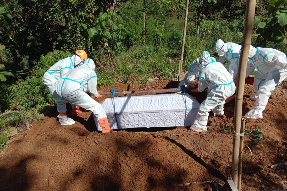 MAKAMKAN—Salah satu tim relawan BPBD Wonogiri memakamkan jenazah secara protokol kesehatan covid-19 di Desa Sonoharjo, Kecamatan Wonogiri, Kabupaten Wonogiri, Jawa Tengah,.