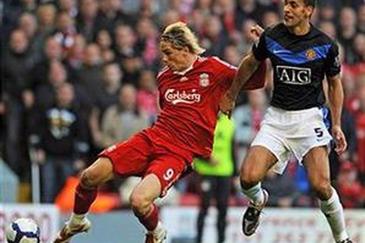 Striker Liverpool Fernando Torres (kiri) dan bek Manchester United Rio Ferdinand dalam duel kedua klub di ajang Premier League. Kedua klub asal Inggris ini menanggung total utang lebih dari satu miliar poundsterling.
