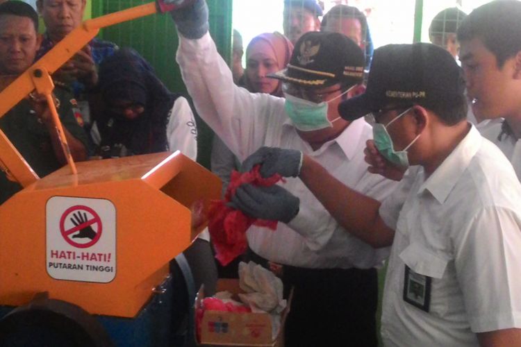 Wakil Bupati Kulon Progo Sutedjo mencoba alat baru pencacah kresek di sebuah bank sampah di Kecamatan Pengasih. Cacahan plastik itu disiapkan untuk campuran aspal bila suatu hari diperlukan.