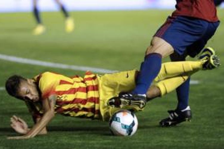 Striker Barcelona, Neymar da Silva (kuning), terjatuh ketika mendapat pengawalan dari bek Osasuna, Marc Bertran, pada laga di Stadion El Sadar, Sabtu (19/10/2013).