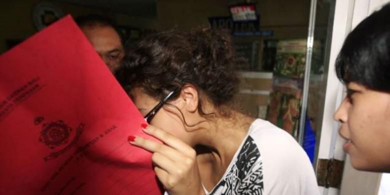 Heather Mack, menutupi wajahnya, saat dibawa polisi terkait pembunuhan ibunya Sheila von Wiese-Mack di Bali (15/8/2014).