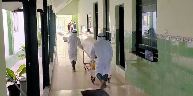 Tenaga kesehatan di RSUD Kardinah Kota Tegal mendorong kereta jenazah pasien, dengan mengunakan baju hazmat, Rabu (30/6/2021)