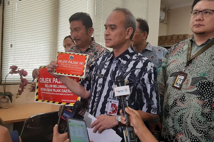 Wakil Kepala BPRD DKI Jakarta Yuandi Bayak Miko menunjukkan stiker yang akan ditempelkan ke kendaraan bermotor yang pajaknya belum dibayar, Kamis (5/12/2019).