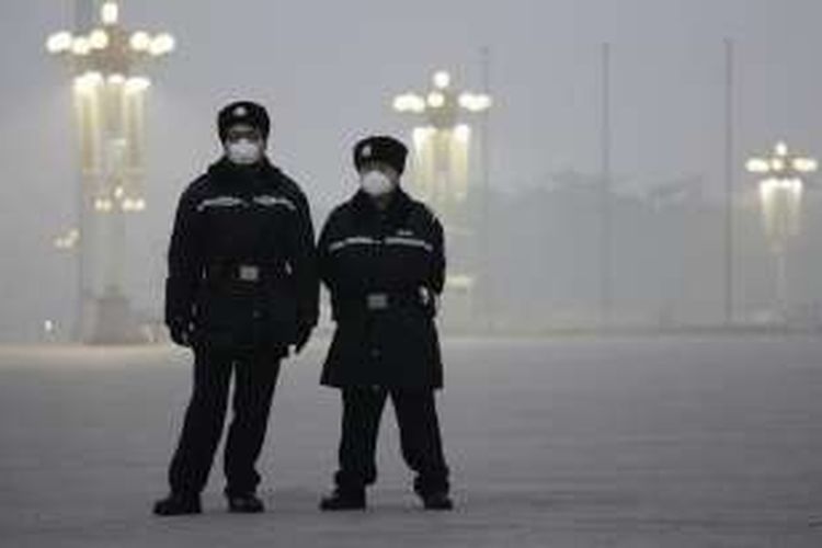 Polisi menggunakan masker di Alun-alun Tiananmen, Beiing, China, karena kabut asap yang sangat pekat di Beijing, 1 Desember 2015.
