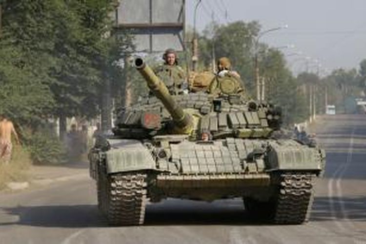 Pasukan pemberontak pro-Rusia menggunakan sebuah tank untuk berpatroli di kota Krasnodon, wilayah timur Ukraina.