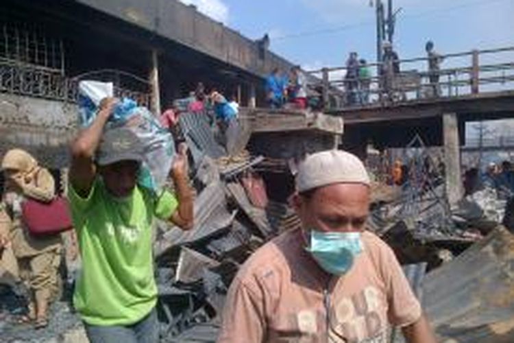 Sejumlah warga membawa barang yang tersisa di dalam pasar Johar, Kota Semarang. 