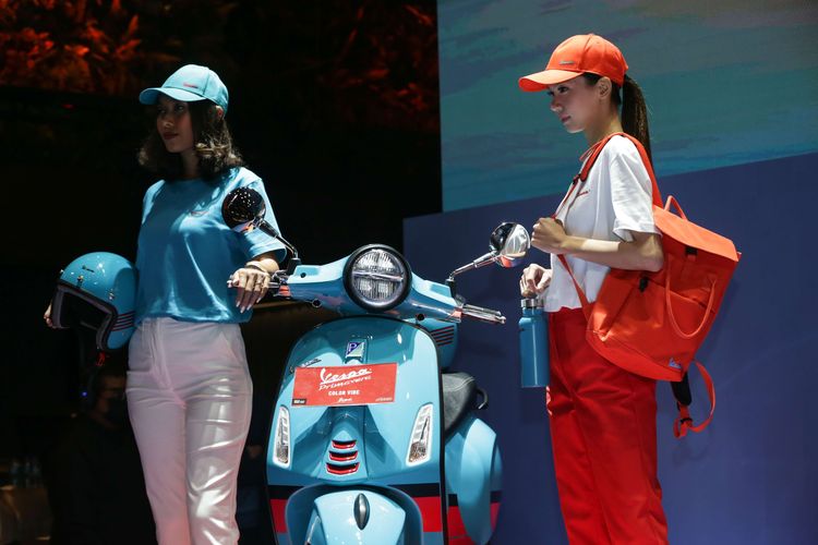 Model memperlihatkan merchandise edisi Vespa Primavera Color Vibe saat peluncuran di Jakarta, Selasa (4/4/2023).  Vespa Primavera Color Vibe hadir dalam dua pilihan warna yaitu orange tramonto dan blue audace.