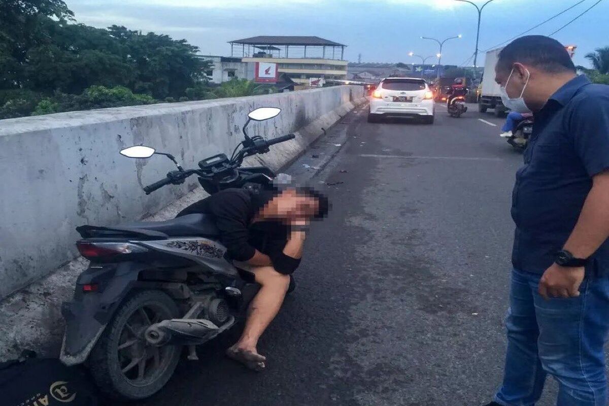 Seorang pria tertidur lelap di atas motor yang terparkir sembarangan di flyover Jatiuwung, Kota Tangerang, Jumat (2/12/2022). Diduga pria tersebut kelelahan dan mabuk akibat minum alkohol.