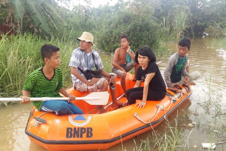 Michael, Raga dan Idam membawa wartawan dengan perahu karet untuk melakukan peliputan banjir di Perumahan Witayu, Kelurahan Sri Meranti, Kecamatan Rumbai, Pekanbaru, Riau, Jumat (23/11/2018).