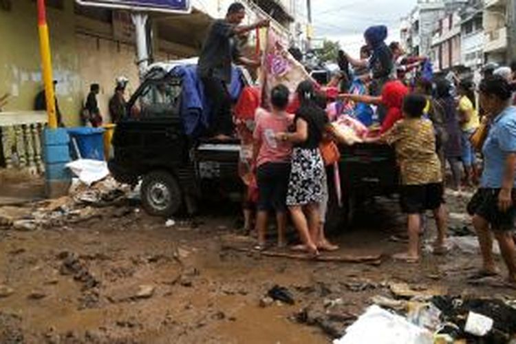 Warga berebutan membeli pakaian yang bekas terendam banjir di Manado. Pakaian itu masih bisa diselamatkan dan layak pakai.