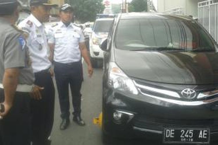Aparat gabungan TNI/Polri dan Dinas Pehubungan Kota Ambon menggembok mobil yang parkir sembarangan di sejumlah ruas jalan di AMbon, Kamis (17/9/2015)