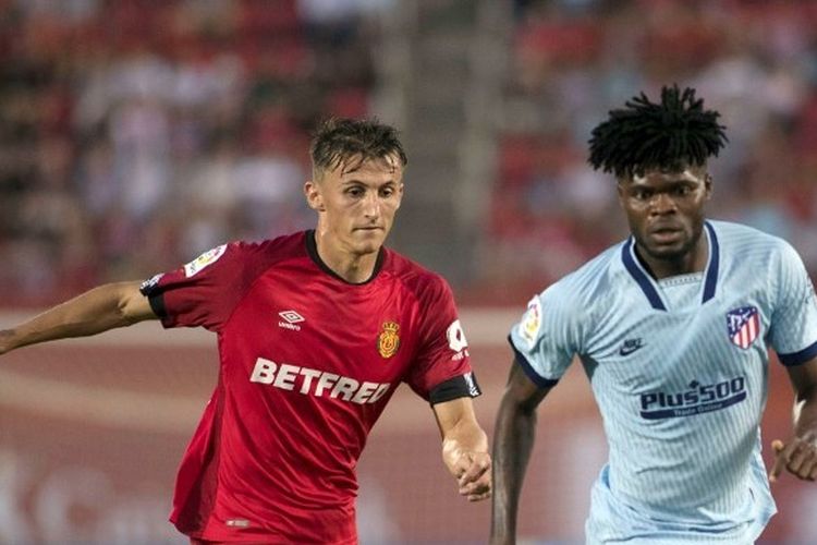 Penyerang Mallorca, Ante Budimir (kiri), sedang berduel dengan gelandang Atletico Madrid, Thomas Partey (kanan), pada pekan keenam Liga Spanyol, 25 September 2019.