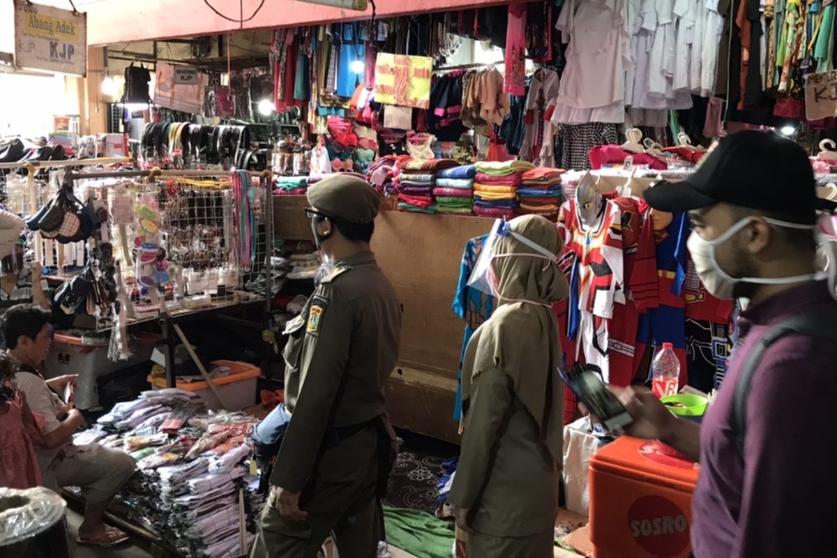 Pihak Satuan Polisi Pamong Praja (Satpol PP) bersama para Aparatur Sipil Negara (ASN) menegur pedagang-pedagang di Pasar Kebayoran Lama yang tak menggunakan masker, Senin (6/7/2020).