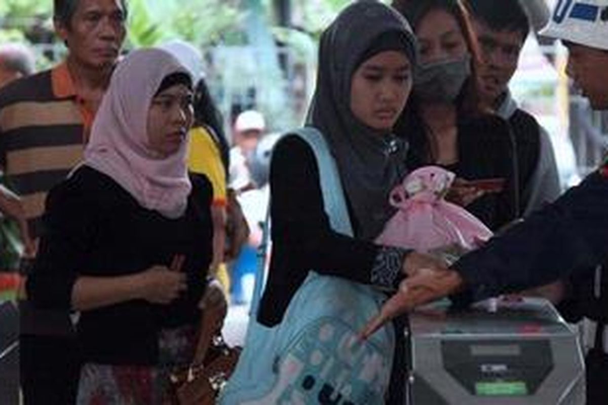 Petugas keamanan membantu penumpang menggunakan tiket elektronik saat ujicoba tiket tersebut di Stasiun Tebet, Jakarta Selatan, Kamis (30/5/2013). Besok, tiket elektronik mulai digunakan secara resmi di seluruh KRL Comuter Line di Jabodetabek.

