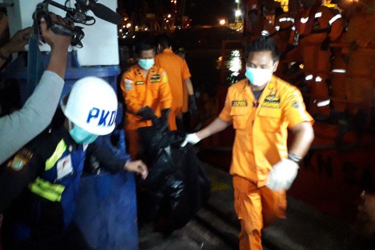 Petugas Basarnas menurunkan kantong jenazah dari KN SAR Sadewa di Dermaga JICT 2 Pelabuhan Tanjung Priok, Kamis (8/11/2018).