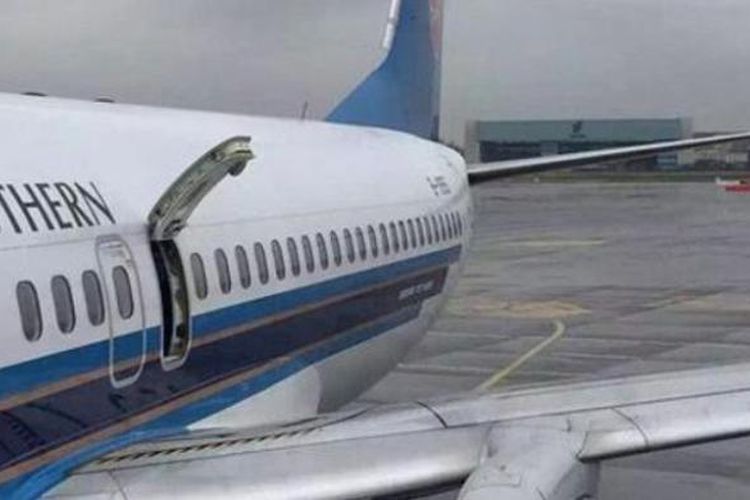 Seorang penumpang membuka pintu darurat pesawat China Southern yang sedang berada di bandara Chengdu, Rabu (9/3/2016).