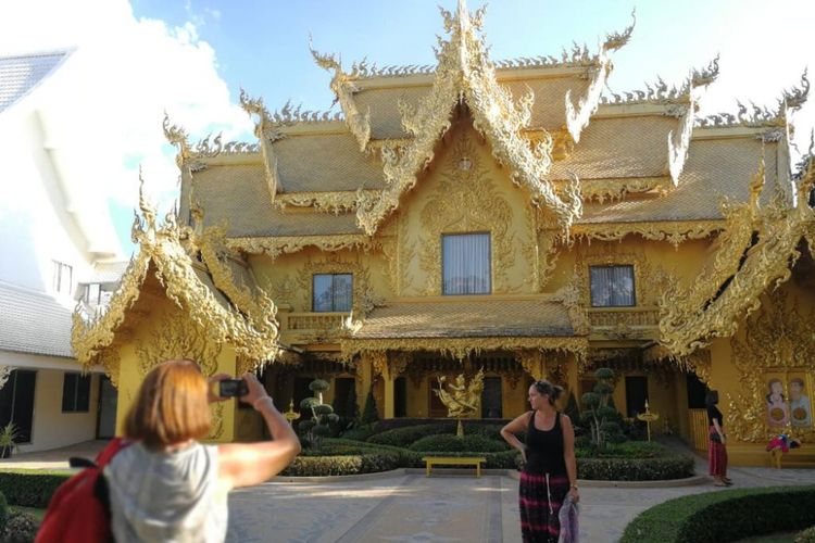 Wisatawan sedang berfoto di depan Golden Toilet di Wat Rhong Kun, Chiang Rai, Thailand.