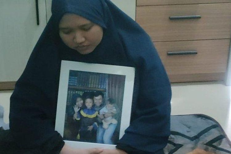 Istri Deni Sobali sedang memeluk foto mendiang suami korban pesawat jatuh. 
