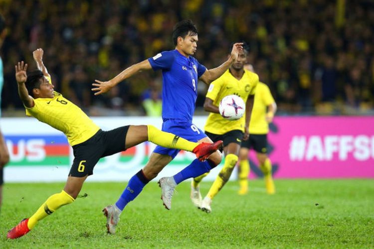 Pemain timnas Malaysia, Syazwan Andik (6) saat mencoba menghentikan laju penyerang Thailand, Supachai Jaided pada semifinal pertama Piala AFF 2018 di Stadion Nasional Bukit Jalil, Kuala Lumpur, 1 Desember 2018.
