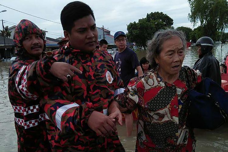 Petugas penyelamat membantu warga menyeberangi banjir di Bukit Mertajam, Penang, Minggu (5/11/2017). Sedikitnya dua orang tewas dan hampir 2.000 warga dievakuasi setelah badai dan banjir menerjang Pulau Penang.