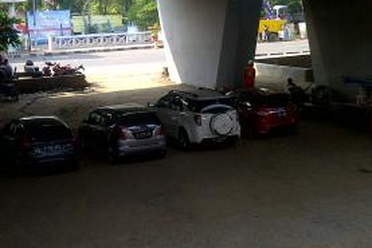 Mobil-mobil parkir di bawah jembatan Grogol, Jakarta Barat, Rabu (13/8/2014). 
